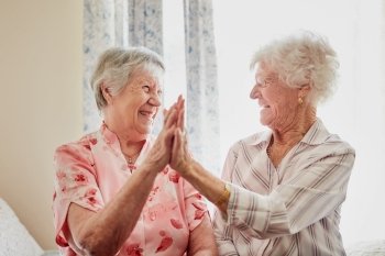 elderly-women-high-fiving-procino-wells-woodland-seaford-lewes-berlin.jpg