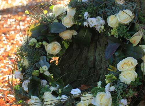 A wreath leaning against the trunk of a tree